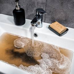 A sink with soap and water in it.