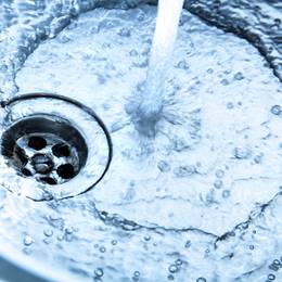 A close up of a sink with water coming out of it.