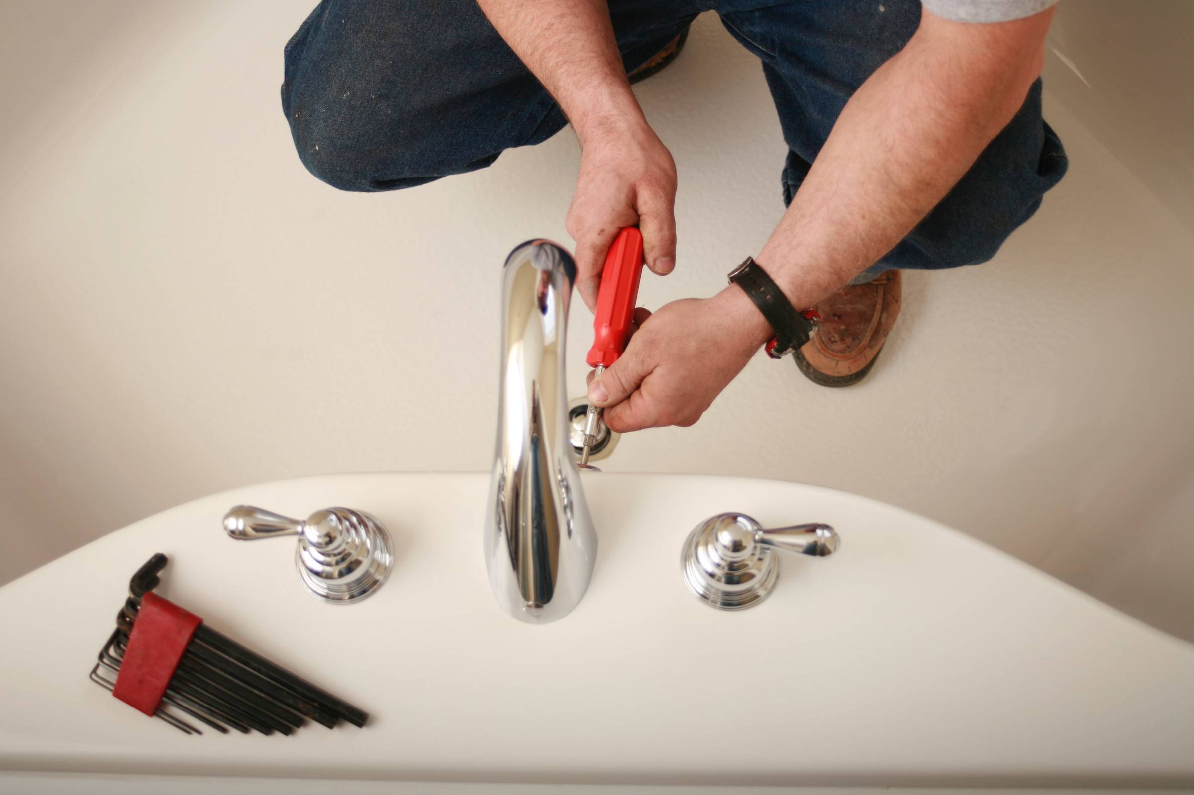 A person using a brush to clean a sink.