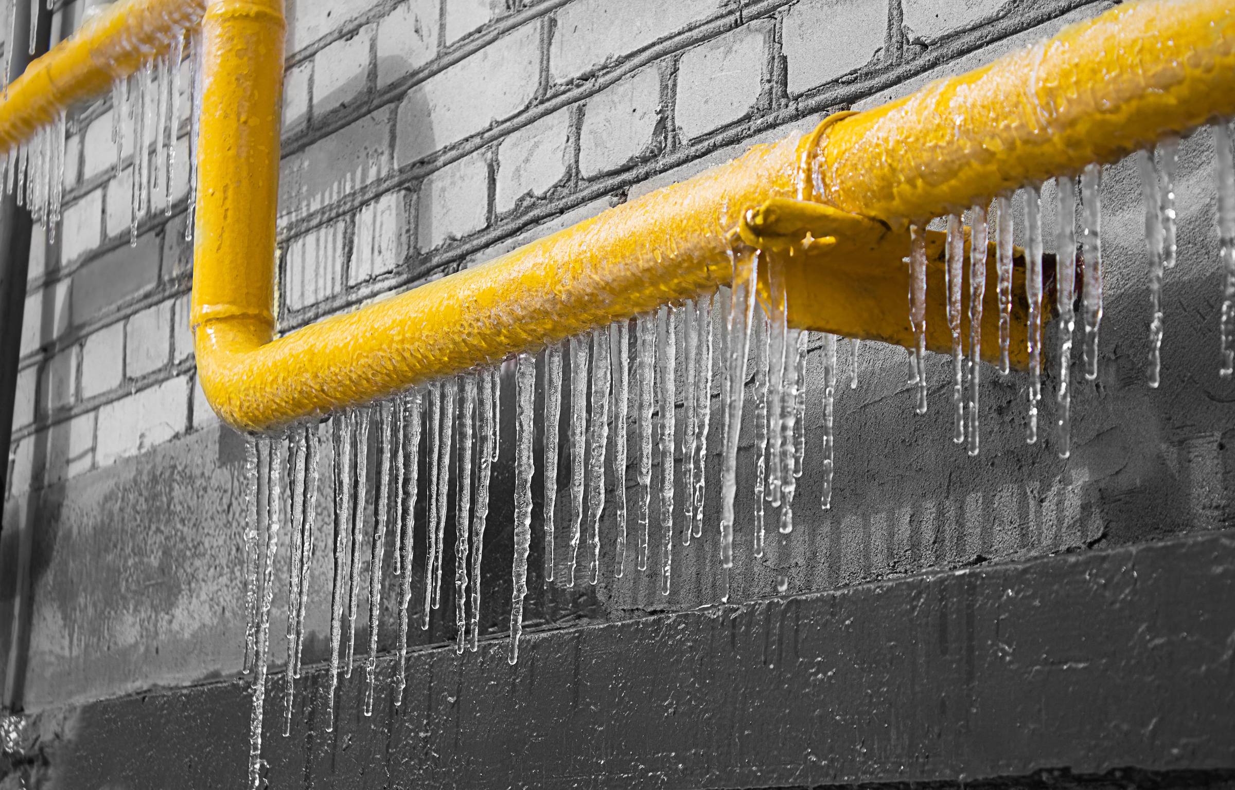 A pipe with icicles hanging from it.