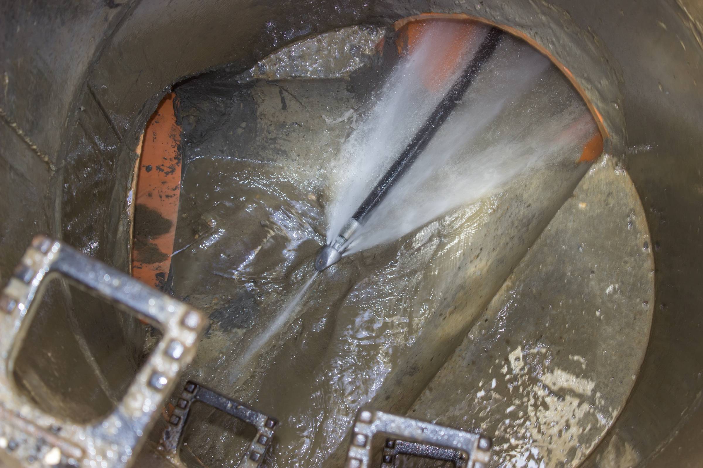 Two men working on a hole in the ground.